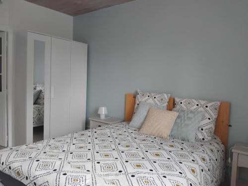 una camera da letto con un grande letto bianco con cuscini di Maison pétanque piscine 2 à 6 personnes a Chevigny-en-Valière