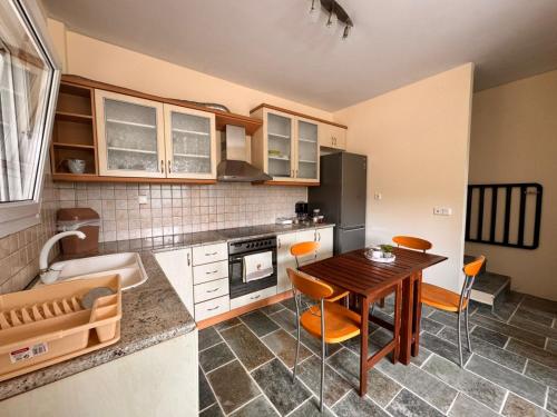 a kitchen with a wooden table and a dining room at The Big Olive Tree in Hanioti
