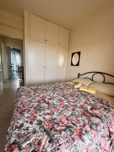 a bedroom with a bed with a floral bedspread at The Big Olive Tree in Hanioti