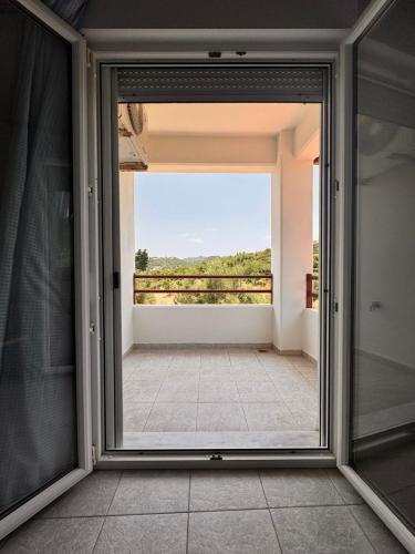 a sliding glass door with a view of a balcony at The Big Olive Tree in Hanioti