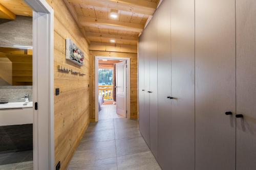- un couloir dans une maison aux murs en bois dans l'établissement 1/2 Chalet : douceur Alpine au Linga, à Châtel