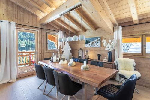 une salle à manger avec une table et des chaises en bois dans l'établissement 1/2 Chalet : douceur Alpine au Linga, à Châtel