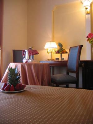 a hotel room with a table with a pineapple on a plate at Grand Hotel Palace in Marsala