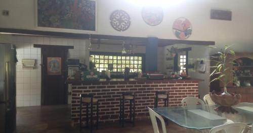 Un restaurante con un mostrador, una mesa y sillas. en Cop30 -Sítio família, en Belém
