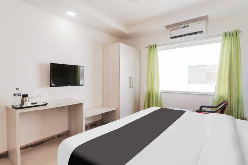 a bedroom with a bed and a desk and a television at Hotel O Civil Lines Near Old Bus Stand in Bareilly