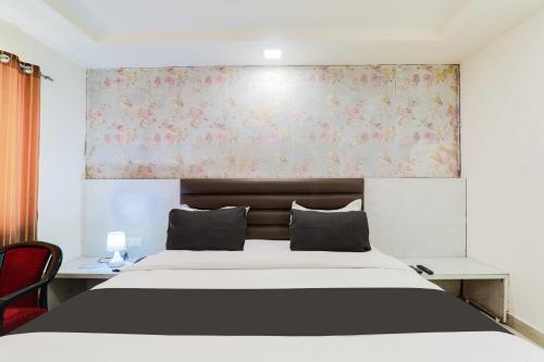 a bedroom with a large bed with a floral wall at Hotel O Civil Lines Near Old Bus Stand in Bareilly