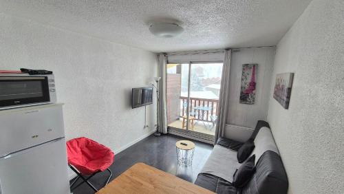 un salon avec un canapé et une télévision dans l'établissement Immeuble Val Benoit coeur station 4 couchages face à la piste de l'aiguille, à Allos