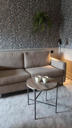 a living room with a couch and a coffee table at Home Hotel Fregatten in Varberg