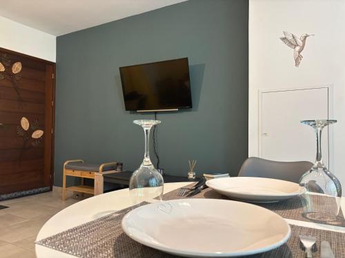 a dining room with a table with glasses on it at Le Petit Colibri - Jardin 80m2 et espace de travail in Rémire-Camp