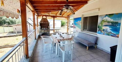 a table and chairs on a porch with a fireplace at SUN and Sea HOUSE Kavala ammolofoi αμμόλοφοι in Eleftheres