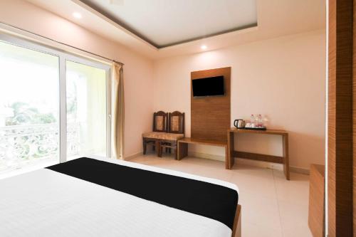 a bedroom with a bed and a large window at Hotel O Paschim Dwar Near Jagannatha Temple in Puri