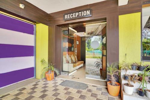 a building with a colorful front door with plants at Hotel O Coorg in Kushālnagar