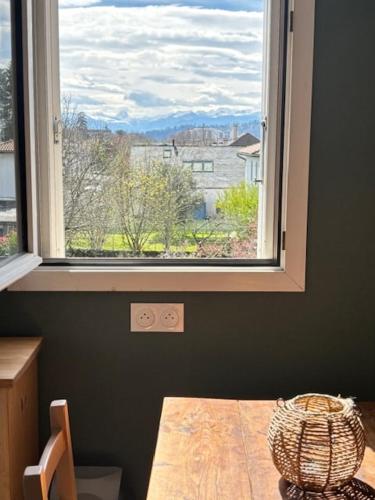 une fenêtre dans une pièce avec une table devant dans l'établissement Petit cocon avec terrasse, à Billère