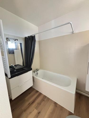 une salle de bain blanche avec un lavabo et une baignoire dans l'établissement Petit cocon avec terrasse, à Billère