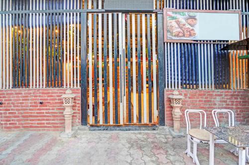 a building with a fence with a table and chairs at Hotel O Mathura Near Railway Station in Mathura