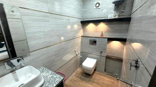 a bathroom with a white toilet and a sink at The Grand Luxury Stay Hotel in Agra