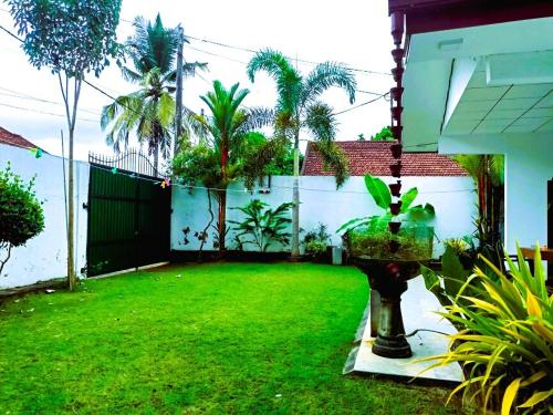 a backyard with a green yard with palm trees at Villa Serenity Weligama in Weligama