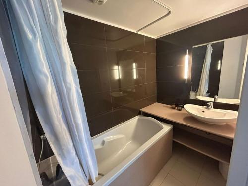 W łazience znajduje się umywalka, wanna i umywalka. w obiekcie Appartement 6 pers avec piscine et sauna à Jausiers - Terrasse exposée sud - Proche Barcelonnette - FR-1-165B-14 w mieście Jausiers