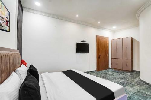 a bedroom with a bed and a television on a wall at Hotel O Ratan Lal Nagar in Kānpur