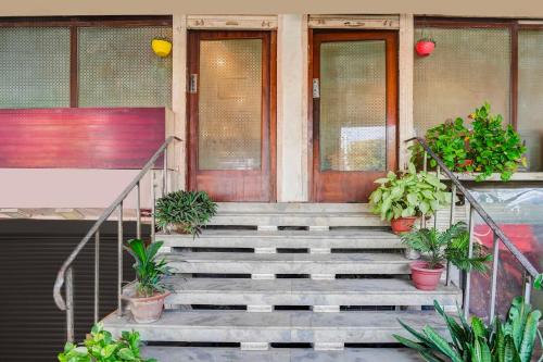 a porch with stairs and potted plants in front of a building at Hotel O Ratan Lal Nagar in Kānpur
