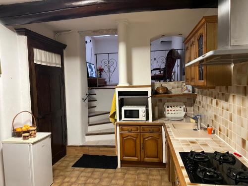 une cuisine avec un évier et une cuisinière four supérieur dans l'établissement Appartement de type provençal, à Vaison-la-Romaine