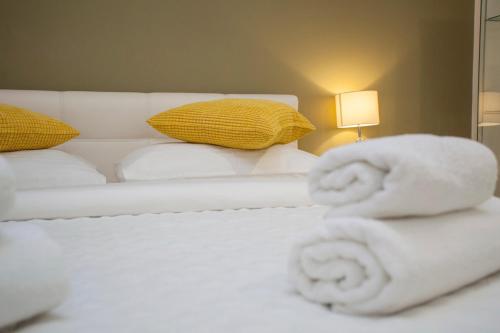 a white bed with towels on top of it at Villa Makarana Apartments in Makarska