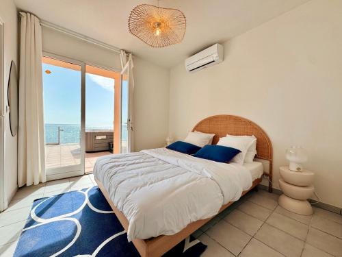 une chambre avec un lit avec vue sur l'océan dans l'établissement Villa pieds dans l eau la Nartelle, à Sainte-Maxime