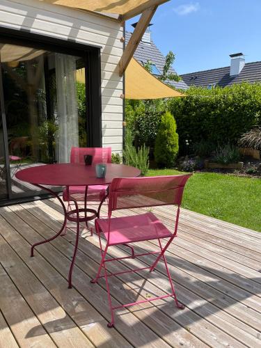 a pink table and chairs sitting on a deck at Pavillon d'Éole in Berck-sur-Mer