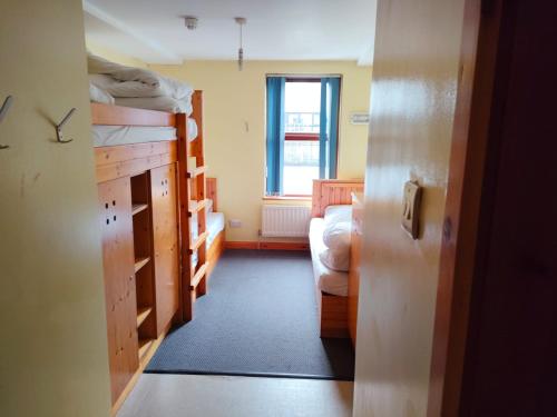 a room with two bunk beds and a window at Bushmills Hostel in Bushmills