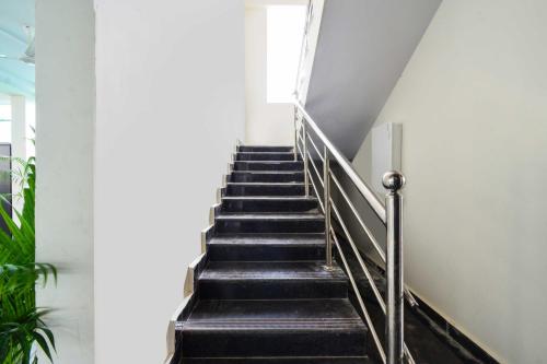 a staircase in a building with black steps at Hotel O Adibatla Hyderabad in Hyderabad