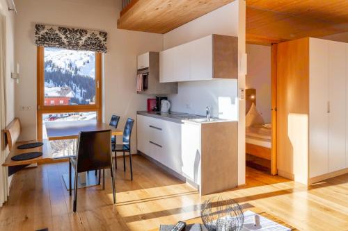 a kitchen with a counter and a table with chairs at Appartementhaus Uga in Damuls
