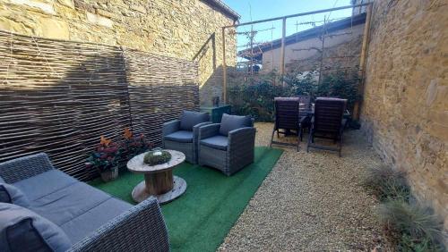 a patio with chairs and a couch and a table at Le Pou'Dingue in Modave