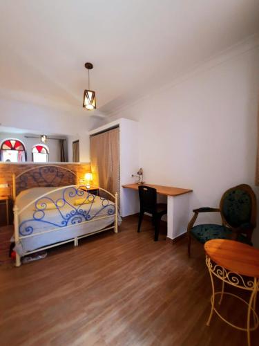 a bedroom with a bed and a desk and a table at DAR Dunia Panoramic terrace in Chefchaouene