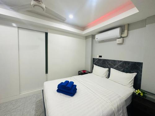 a bedroom with a white bed with a blue box on it at Patong best location Apartments, 2 bedrooms in Patong Beach
