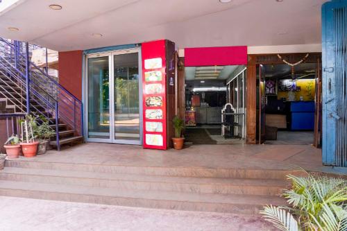 a store front with a red door and stairs at Super Hotel O Hubli City Center in Hubli