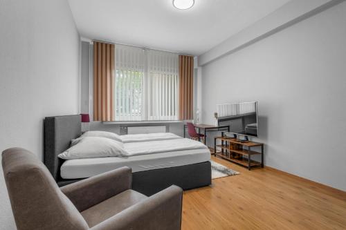 a bedroom with a bed and a couch and a chair at Domloge Lofts & Apartments in Cologne