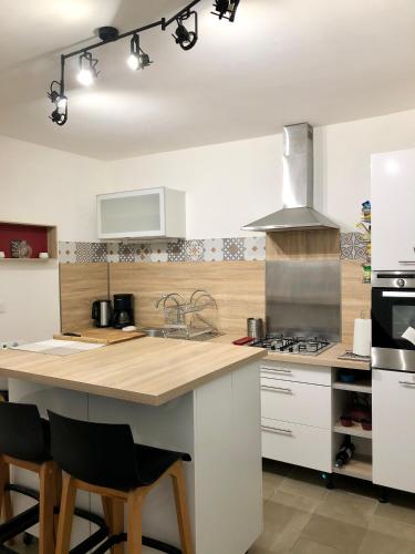 une cuisine avec un grand îlot en bois dans l'établissement Au bonheur du Fez, à Orgnac-lʼAven