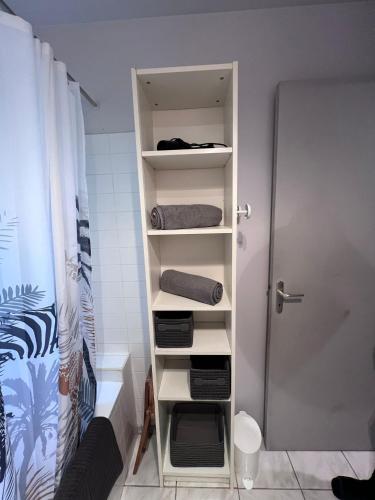 La salle de bains est pourvue d'une étagère, de serviettes et d'une douche. dans l'établissement Les Caselas, à Gramat