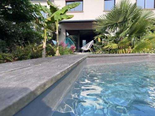 une piscine devant une maison dans l'établissement Maison Klein 8 voyageurs proche Bordeaux, à Mérignac