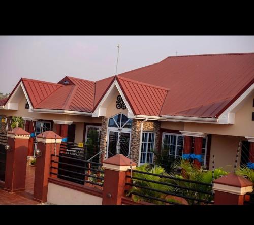 a house with a red roof with a fence at Lizab Lodge 