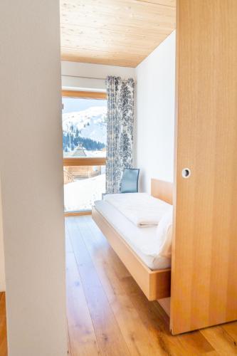 a bedroom with a bed and a large window at Appartementhaus Uga in Damuls