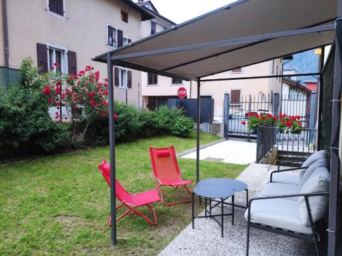 two chairs and a couch under an umbrella at Apartments and holidays Cav Chiara Tione di Trento in Tione di Trento