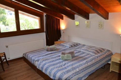 un dormitorio con una cama con dos almohadas. en Résidence Arnica 3 pièces, en Nendaz
