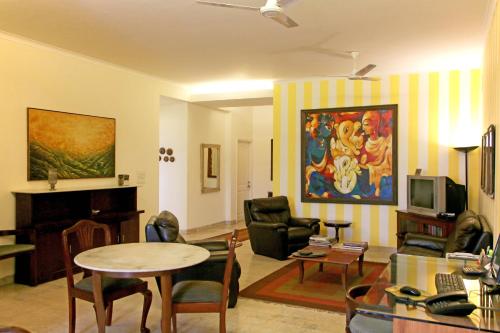 a living room with a table and chairs and a living room at Colonel’s Retreat in New Delhi