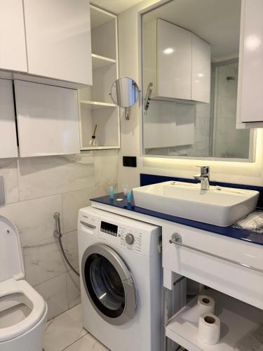 a bathroom with a washing machine and a sink at ORBI CITY OFFiCIALY in Angisa