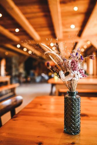 a vase filled with flowers sitting on a table at Le Marie Lydie - Chambre d'hôte in La Chapelle-dʼAbondance