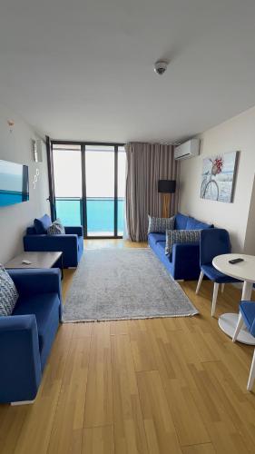a living room with blue couches and a table at ORBI CITY OFFiCIALY in Angisa