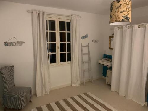 Cette chambre dispose d'une échelle, d'une chaise et d'une fenêtre. dans l'établissement Grande maison normande de 250 m2 1ha - aperçu mer, à Auberville