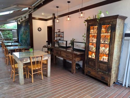 a restaurant with wooden tables and chairs and a cabinet at Flamboyant Residence in Fernando de Noronha