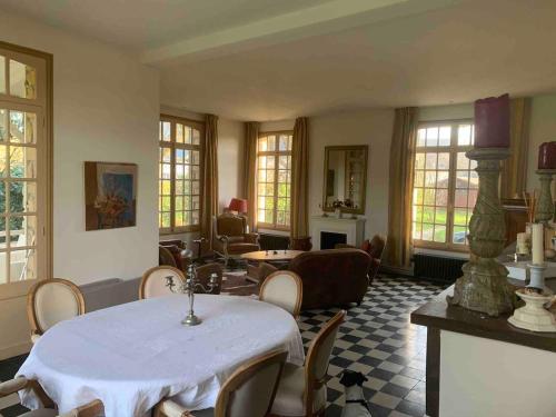 un grand salon avec une table et des chaises dans l'établissement Grande maison normande de 250 m2 1ha - aperçu mer, à Auberville